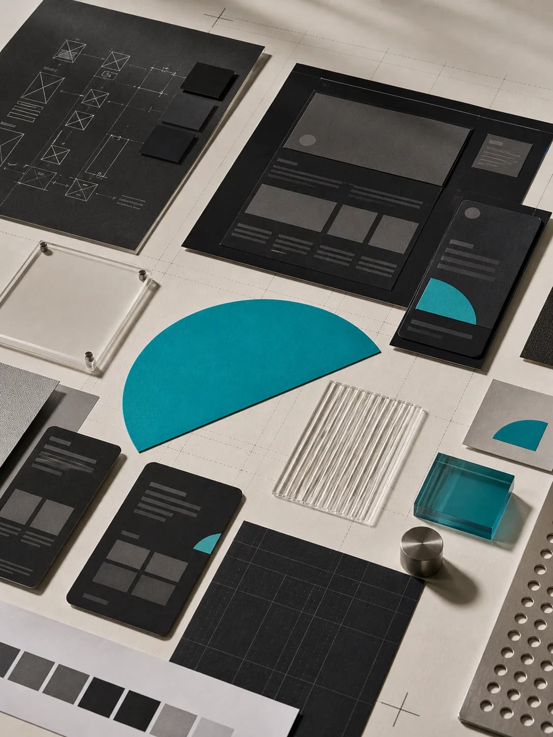 Website layout studies and material samples arranged during the design process.